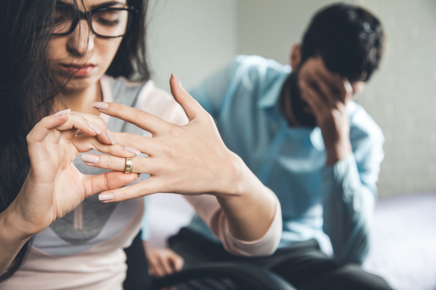 Unhappy women removing wedding ring from hand