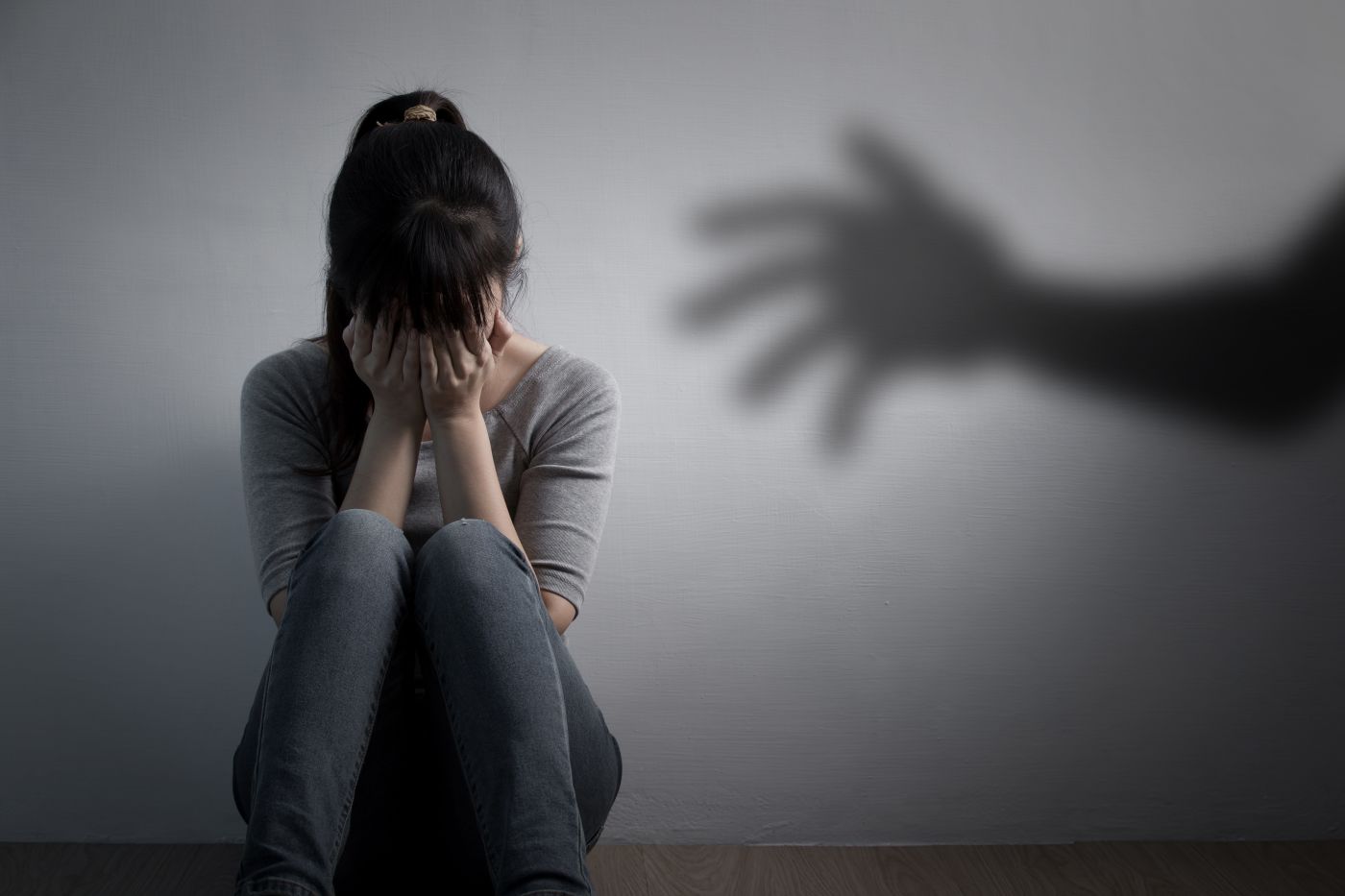 Shadow hand approaching crying women