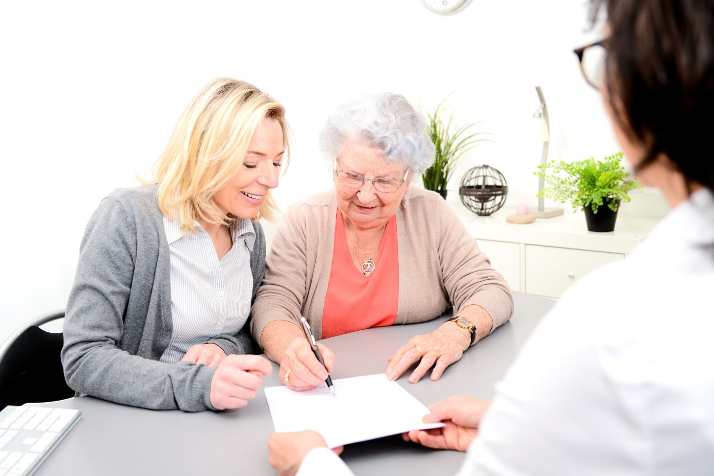Elderly women and daughter signing a legal document