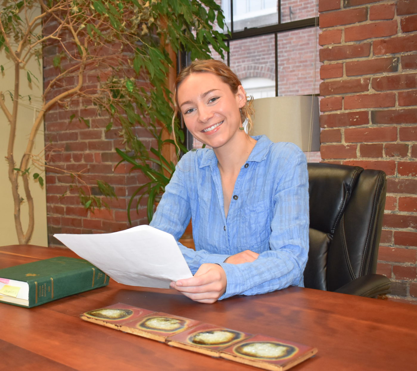 A woman sits and smiles at the camera.