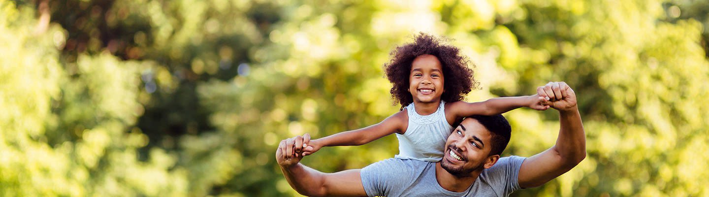 Father carrying his daughter on his shoulders
