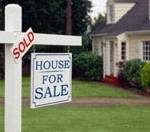 House for sale sign with a sold sign above it