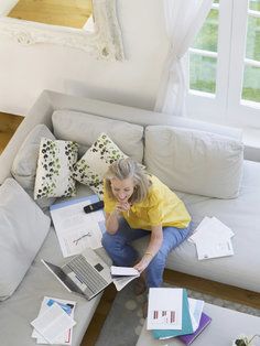 Woman looking over bills on her couch