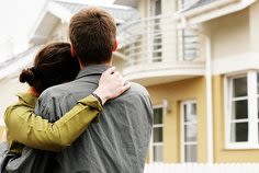 Couple hugging in front of new house