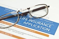 Life Insurance Application with glasses on top