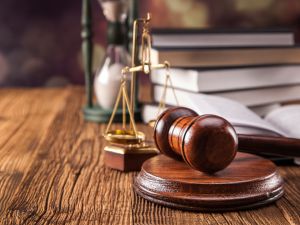 gavel, scales of justice, hourglass, and books on wood table