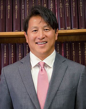 Headshot of Attorney Marcus D. Crow in front of the Bookshelves