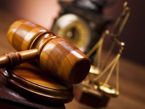 Gavel with scales of justice and old fashioned clock in the background