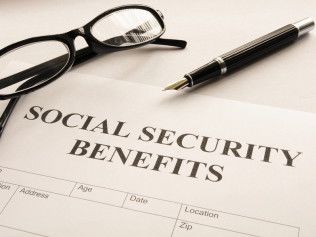 Social security benefits document with glasses and a pen