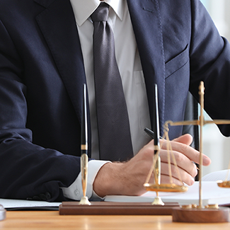 Man signing documents with scales of justice