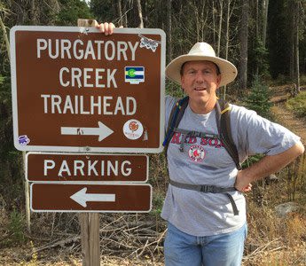 Attorney Jamie Mcdonough Standing Next to a Hiking Trail Sign