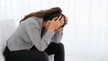 Stressed woman with her head in her hands