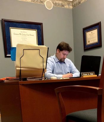 Attorney Ryan A. Slep sitting and writing at his desk