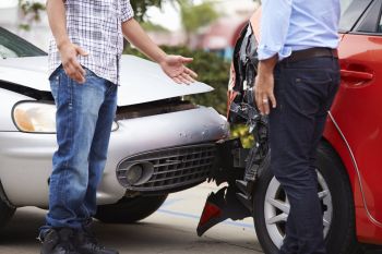 Two men speaking to each other after a fender bender