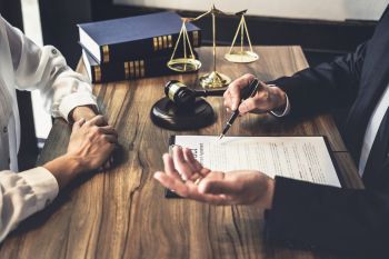 Attorney's desk with a form, books, scales, and a gavel. 