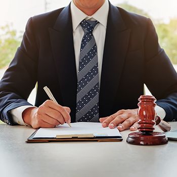 Man writing on a document with gavel