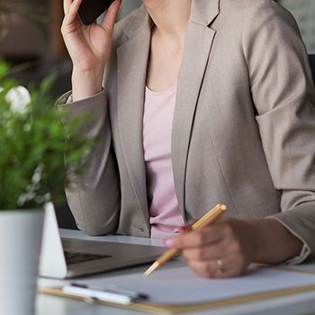 Business woman at her desk talking on the phone