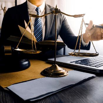 Lawyer working at his desk with a justice scale next to him