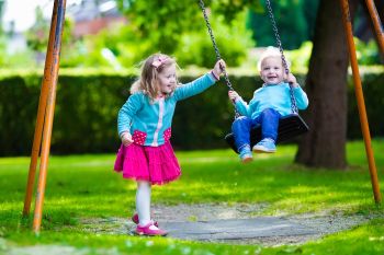 Two Young Children Swinging on a Swing