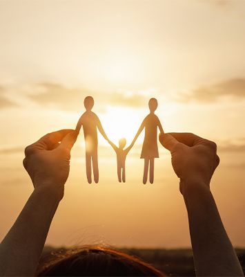 Little girl holding family figures in sunset setting