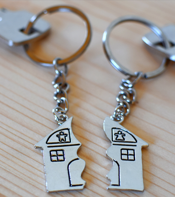 Two keys with splitted or broken key rings with pendant in shape of house