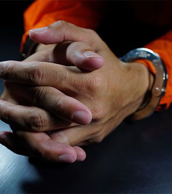Handcuffed hands on table