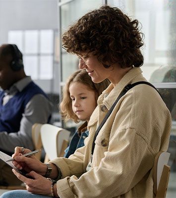 Young mother and daughter filling immigration form