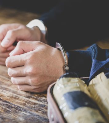 Handcuffed man with drug pouches