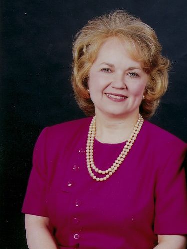 Cindy Tague in pink dress with pearl necklace