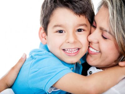 Smiling woman hugging young smiling boy