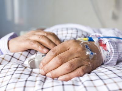 close up of hands of person in a hospital bed