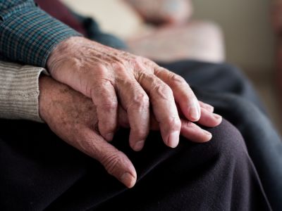 close up of elderly couple holding hands