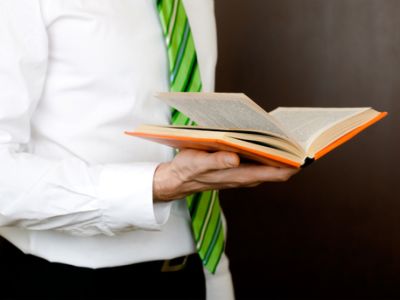 Man in suit reading book