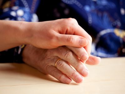 Close up of a young hand holding an older hand