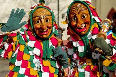 Two masked people dressed in colorful clothing