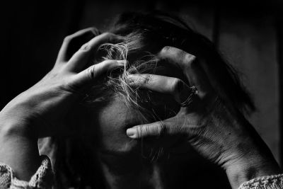 Woman with hands in hair looking down