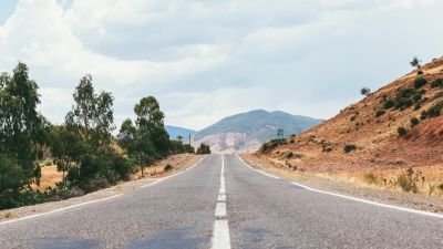 Empty desert road with scenic hills ahead