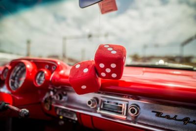 Two red dice decor hanging inside car with red interior