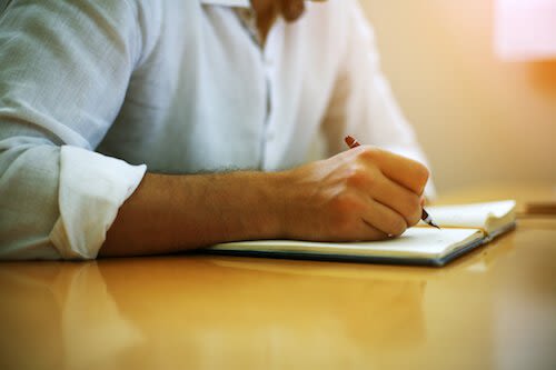 Man Writing on a Notebook