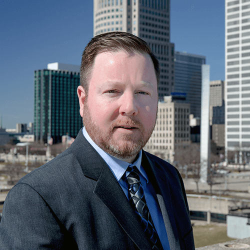 Kevin Kavanaugh in front of buildings