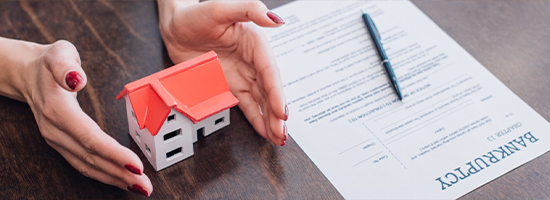 Model house and bankruptcy forms on desk