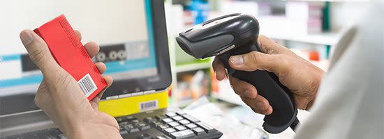 Person in labcoat scanning barcode at counter