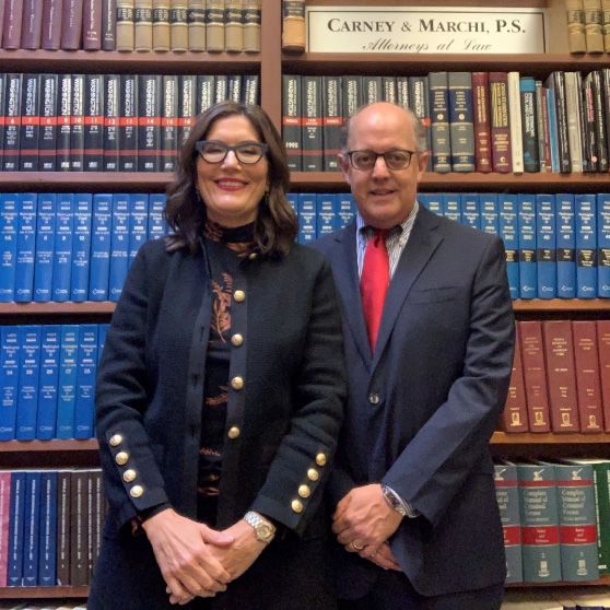 Attorney Carney & Marchi in front of a bookshelf