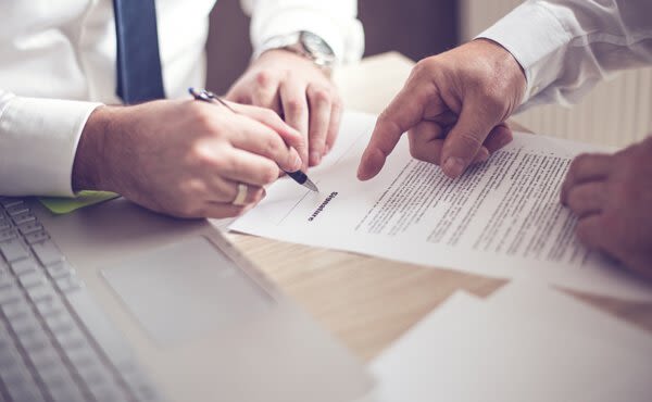 A man directing another to sign a contract