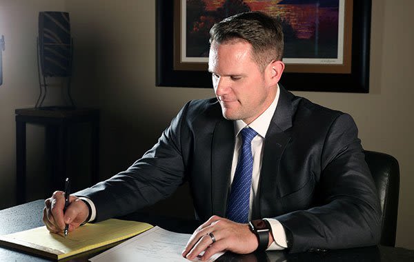 Attorney Eric Day Writing on a Notepad