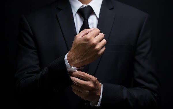 Man in suit adjusting his sleeves