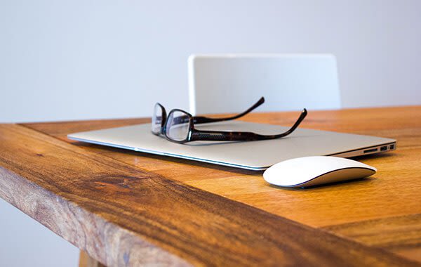 Closed laptop, mouse, and glasses