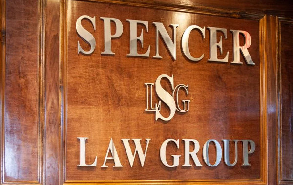 Wall with gold lettering on it reading Spencer Law Group