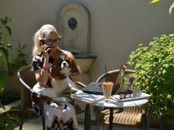 Woman on the phone with a dog in her lap