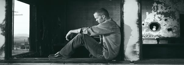 Man Sitting Head Down in Black and White